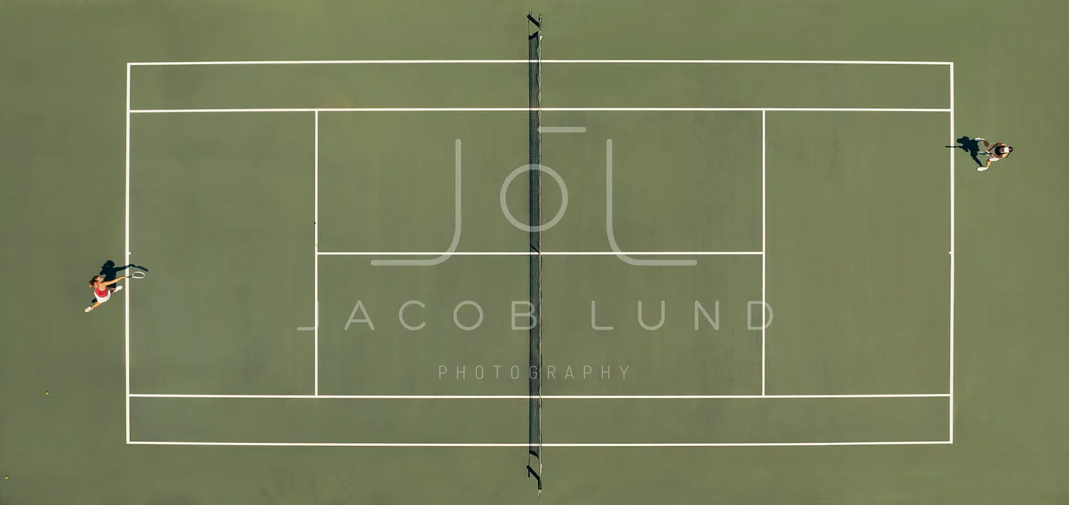 Aerial top view of a tennis match on a hardcourt field with players in action