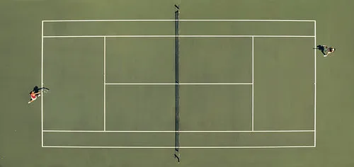Aerial top view of a tennis match on a hardcourt field with players in action