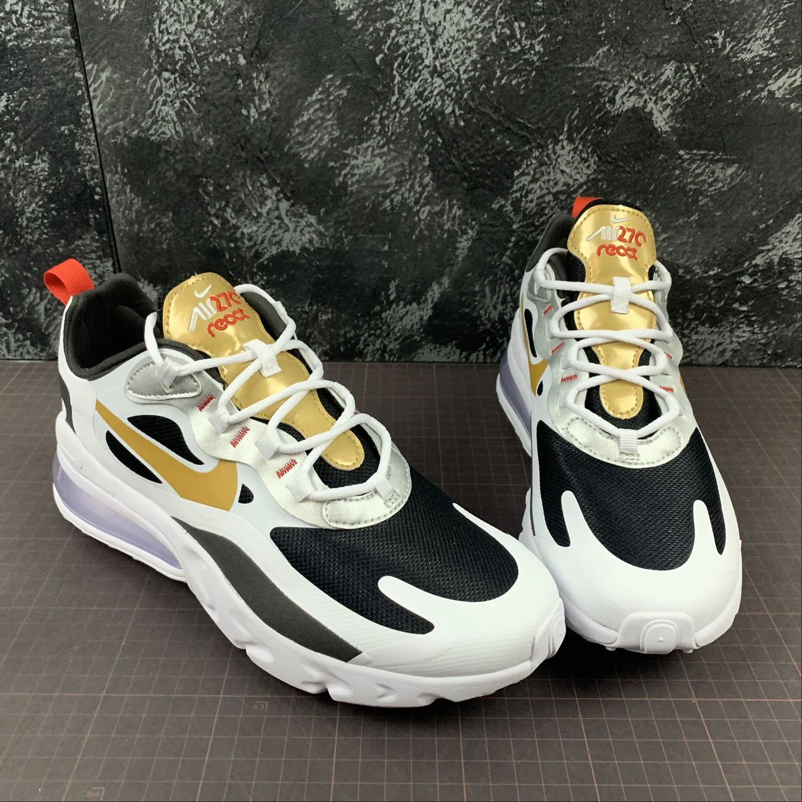 running in a tram station area shoes Air Max 270 React Vast Grey Metallic Gold-Black CT3433-001